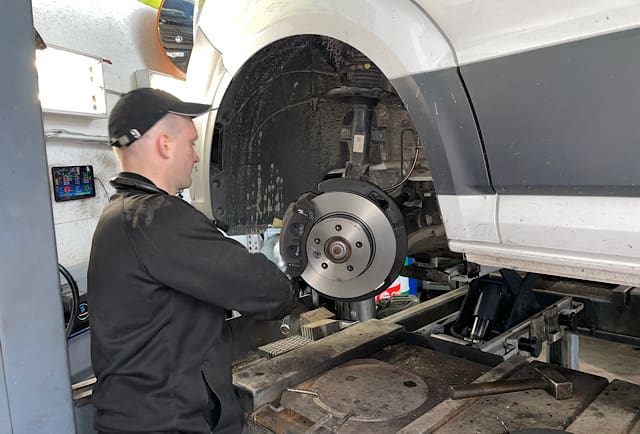 Meister Andrey bei Bremsreparatur VW Crafter – Bremssattel und Beläge ausgebaut