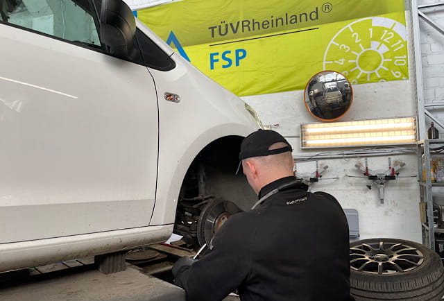 Mechaniker demontiert rechtes Rad am VW up – Zugang zur Antriebswelle fuer Manschettenwechsel